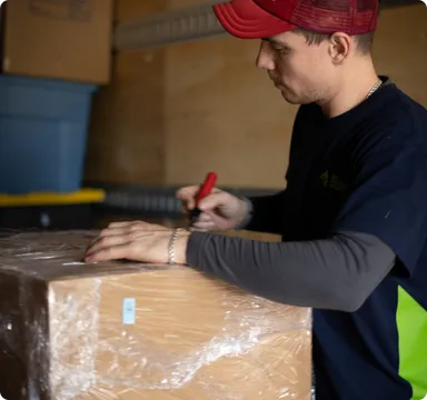 Mover labelling a wrapped box before it is loaded