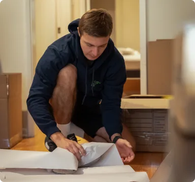 Mover laying floor protection before carrying items out