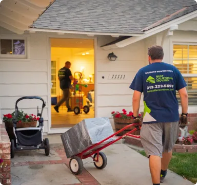 Mover carrying wrapped furniture into a new home