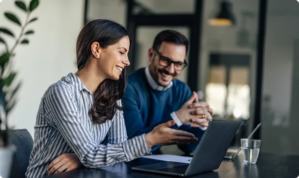 Couple reviewing their approved moving plan on a laptop